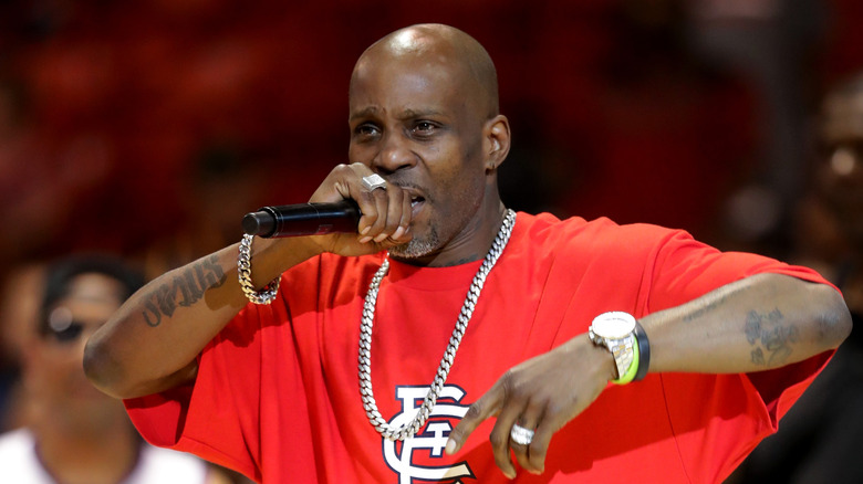 DMX in a red shirt rapping into a microphone