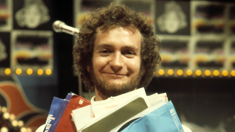 Kenny Everett smiling with records