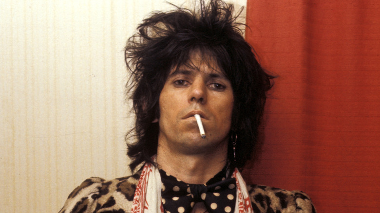 A young Keith Richards with wild hair and a cigarette dangling from mouth