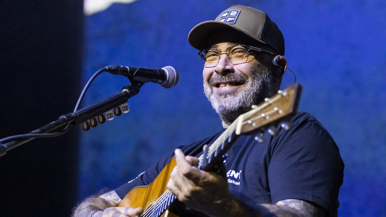 Aaron Lewis playing guitar and smiling concert