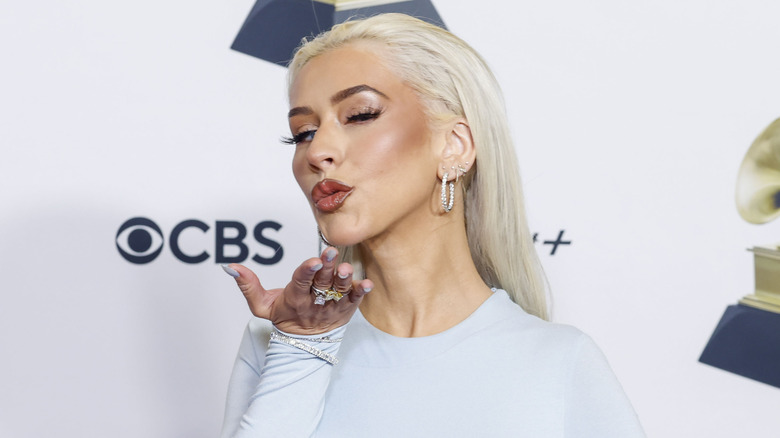 Christina Aguilera blowing a kiss white shirt at event