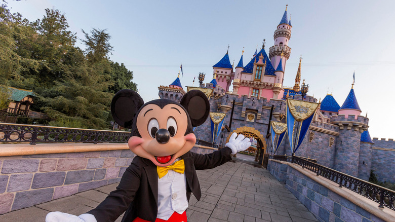 Mickey Mouse posing in front of Disneyland