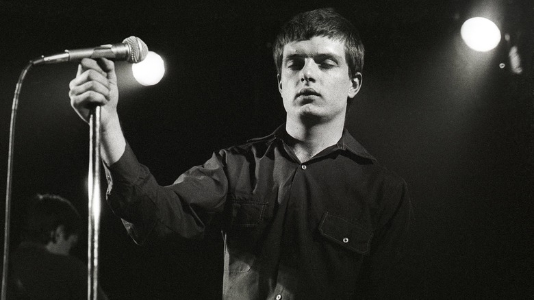 Ian Curtis holding mic stand