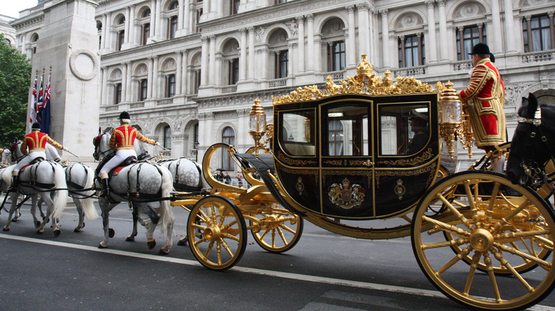 Golden horse-drawn carriage footmen in london