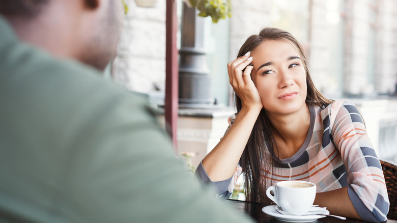 woman looking bored talking to a man