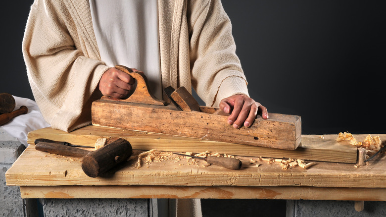 hands using ancient carpentry tools