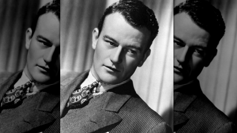 Young John Wayne leans left suit