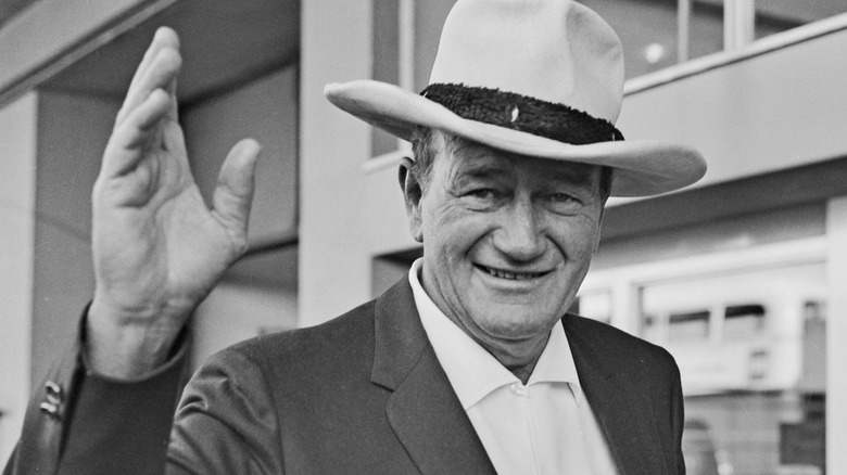 John Wayne smiles and waves