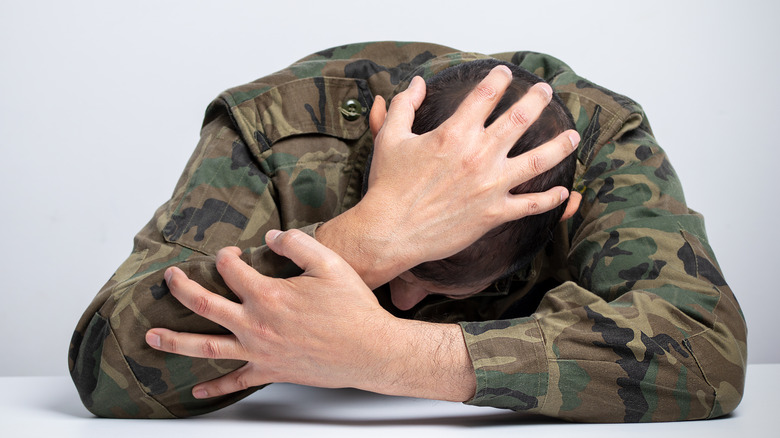 Soldier holding head in hands