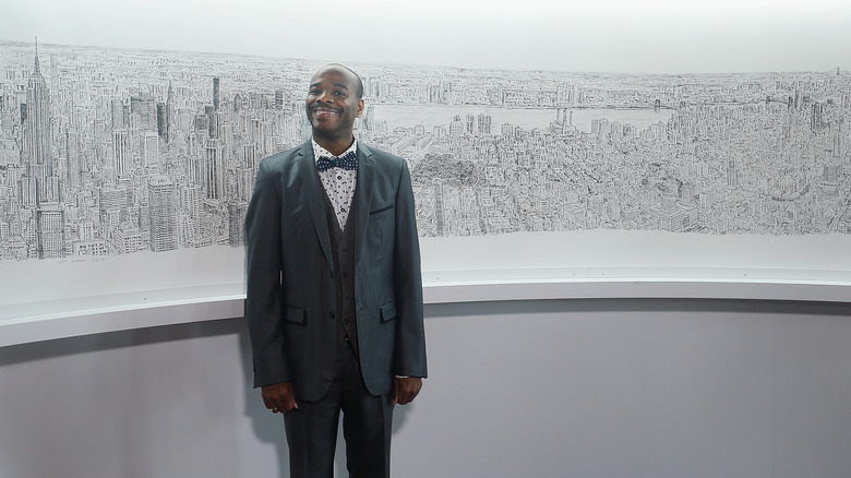 Stephen Wiltshire in front of one of his landscapes