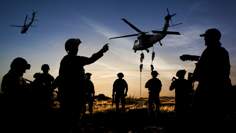 Siilhouetted special forces helicopter drop