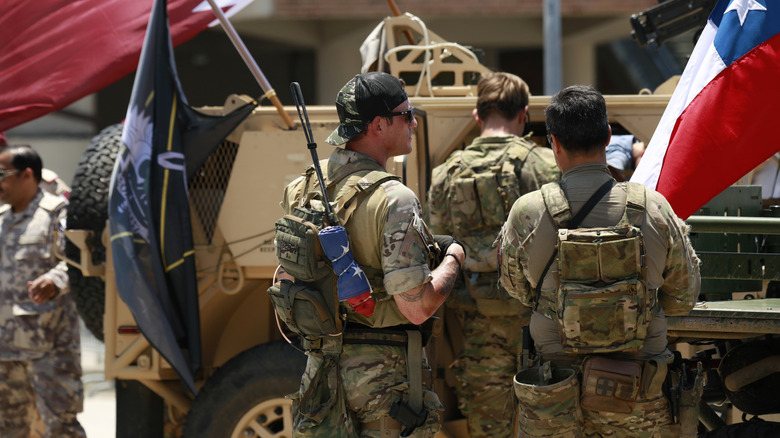 Green Berets in front of an armored vehicle