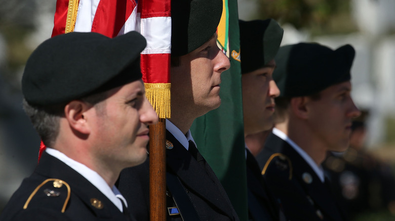 Four Green Berets in a row with flags