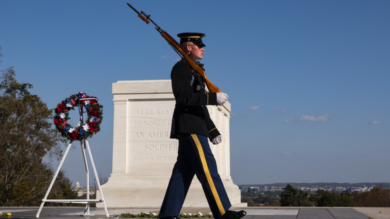 Guard walks past the Tomb with a rifle