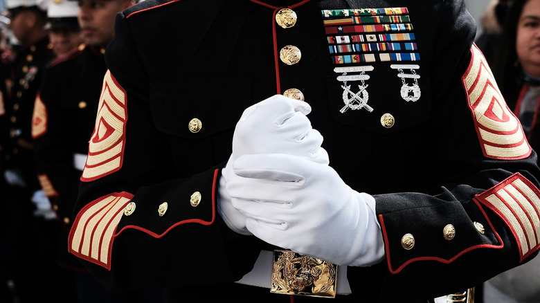 Marine adjusts gloves while on the march