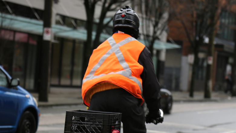 Man in a reflective vest rides his bike