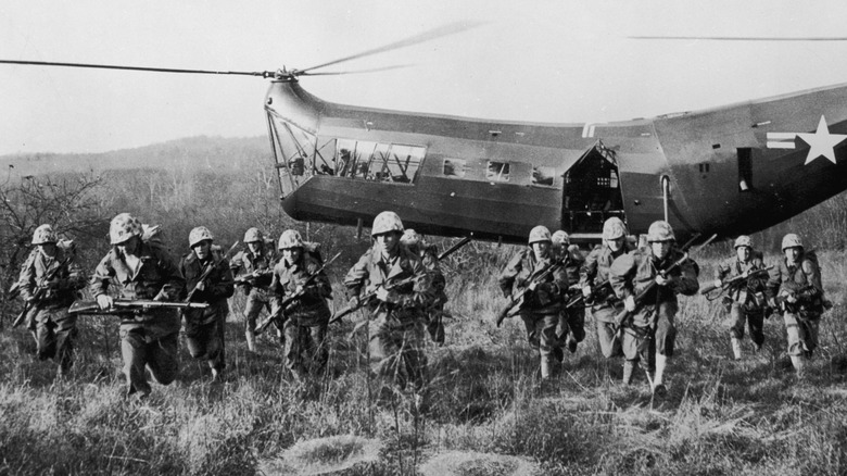 Marines charge from a helicopter