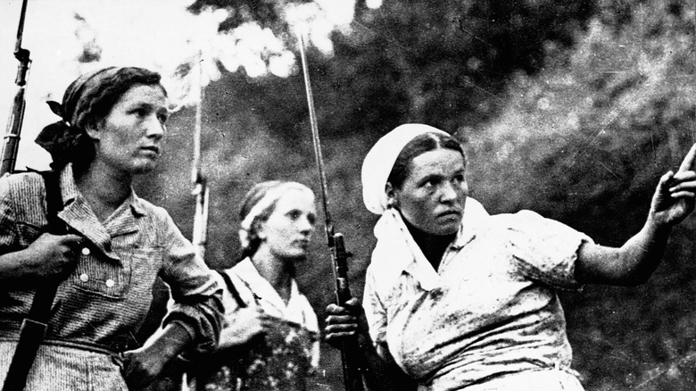 Female Soviet fighters hold guns