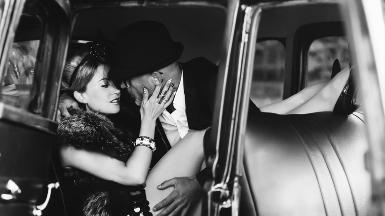 man and woman kissing in car