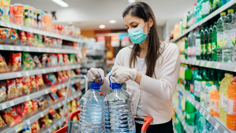 woman buys water at supermarket