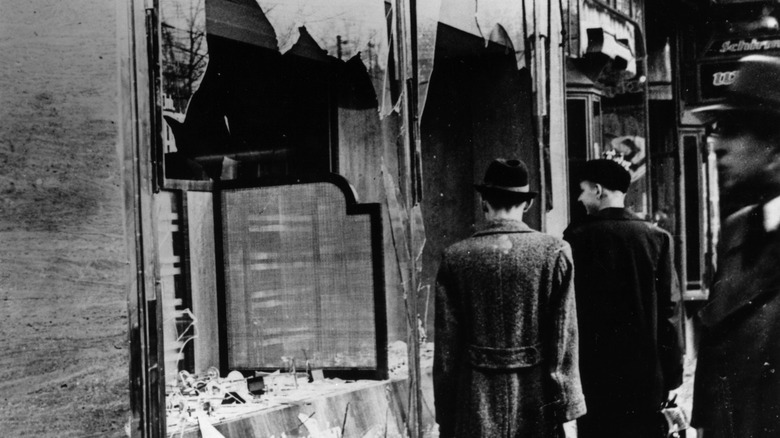 People look at broken windows in aftermath of Kristallnacht