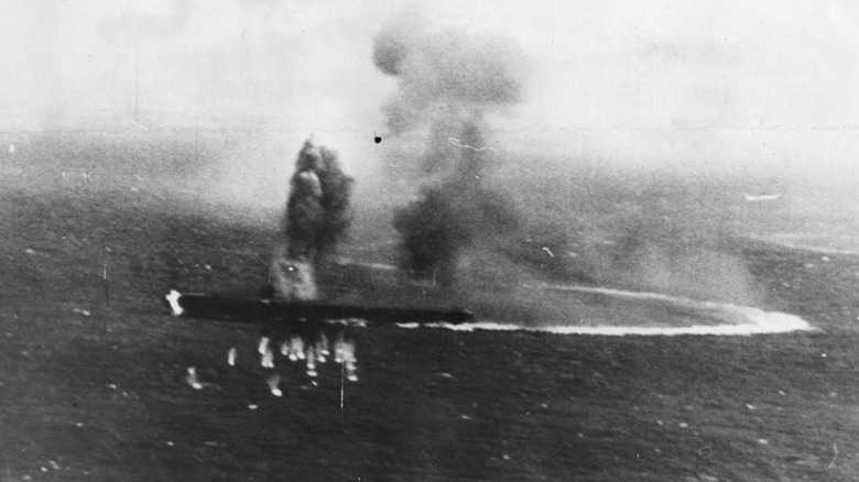 Burning Japanese aircraft carrier Shokaku takes evasive action to avoid American bombs during the Battle of the Coral Sea.