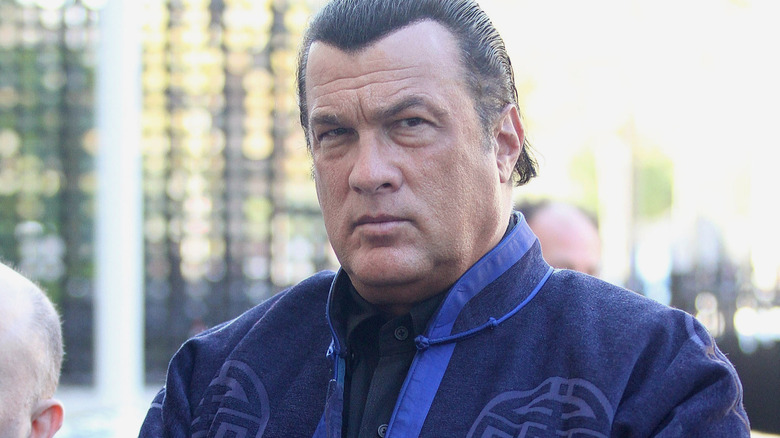 Steven Seagal glowering in a blue gi-like jacket