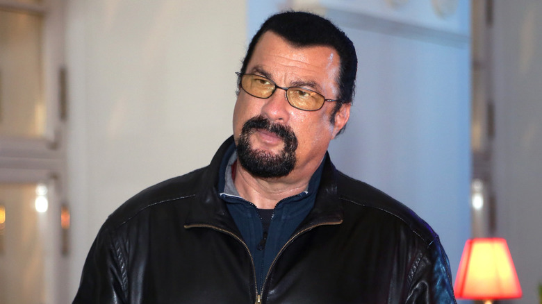 Steven Seagal in a black leather jacket looking annoyed