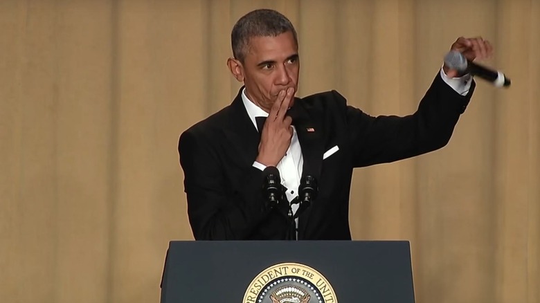 obama black suit two fingers to lips mic drop