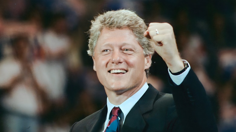 Bill Clinton black suit smiling fist raised