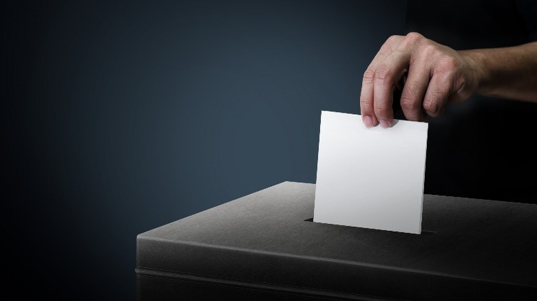 hand putting ballot in box