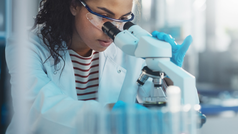 scientist looking through a microscope