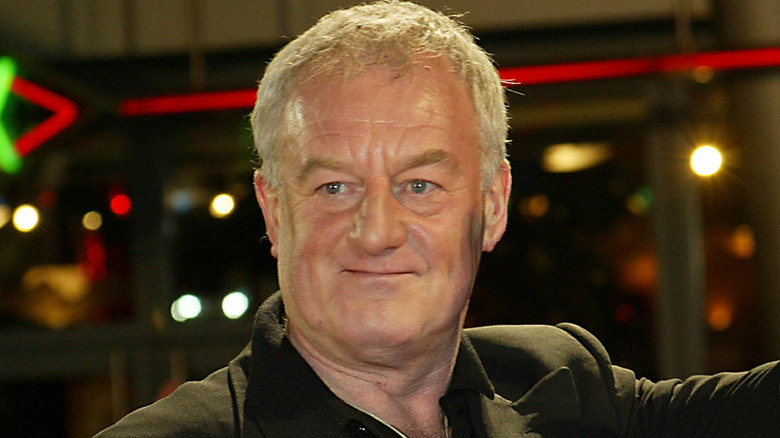 Bernard Hill smirking and looking away