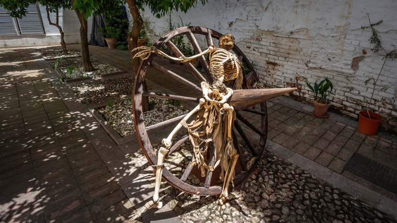 human skeleton on a breaking wheel