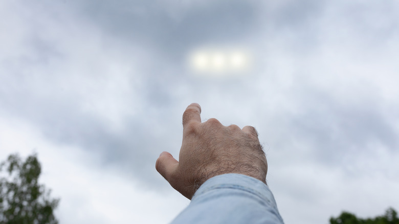 Hand pointing at UFO lights
