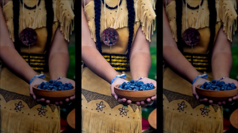 Native American girl holding blueberries
