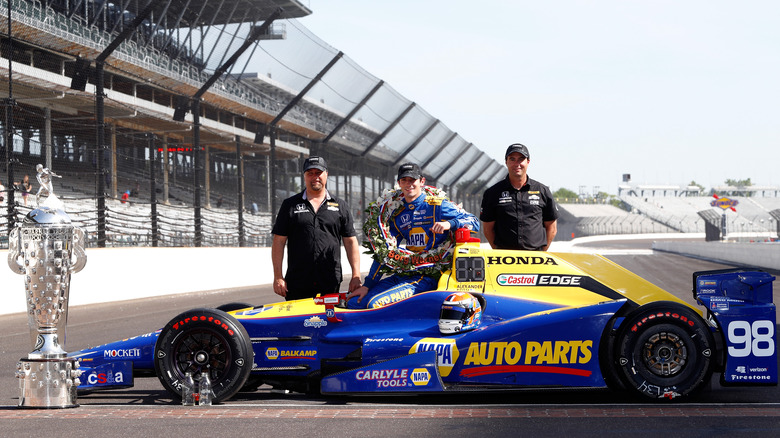 michael andretti, alexander rossi, bryan herta posing with car