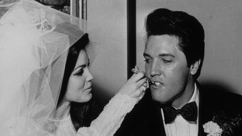 Priscilla Presley feeds Elvis a piece of wedding cake