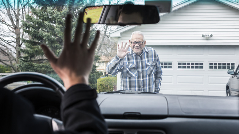 person waving goodbye to an elderly man