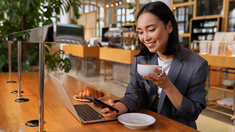 person in a coffee shop with laptop