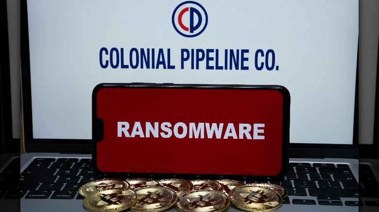 Colonial Pipeline logo on laptop with smartphone and bitcoin