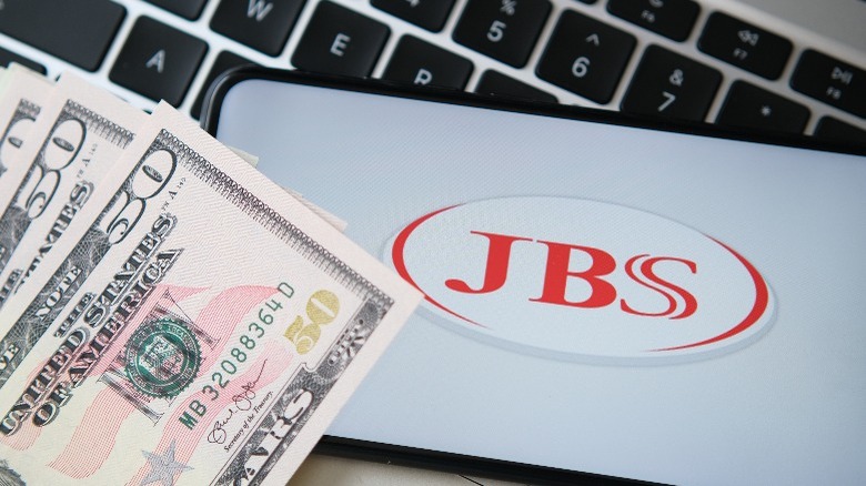 Cash next to JBS Foods logo on phone and keyboard