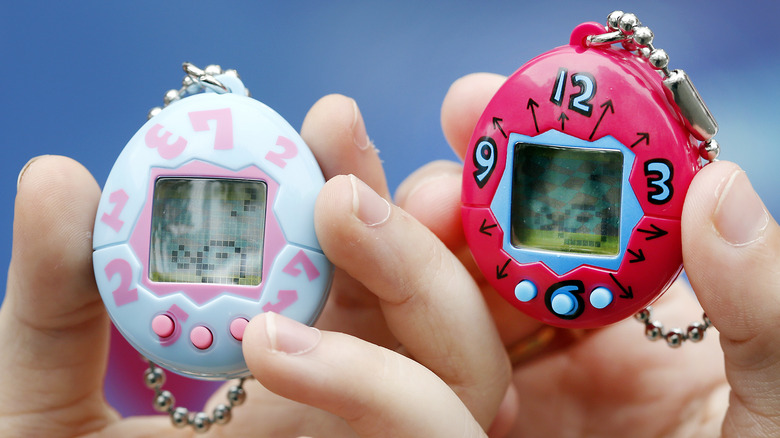 hands holding tamagotchis