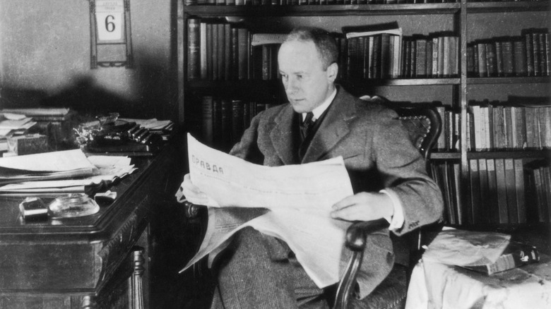 walter duranty in chair reading russian newspaper