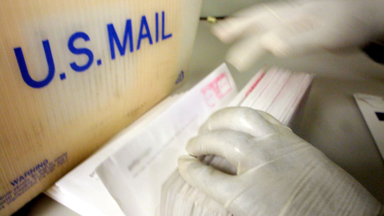 man in gloves investigating anthrax case, searching mail