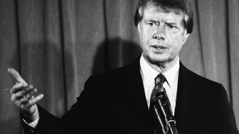 Jimmy Carter dark suit mic curtain speaking 