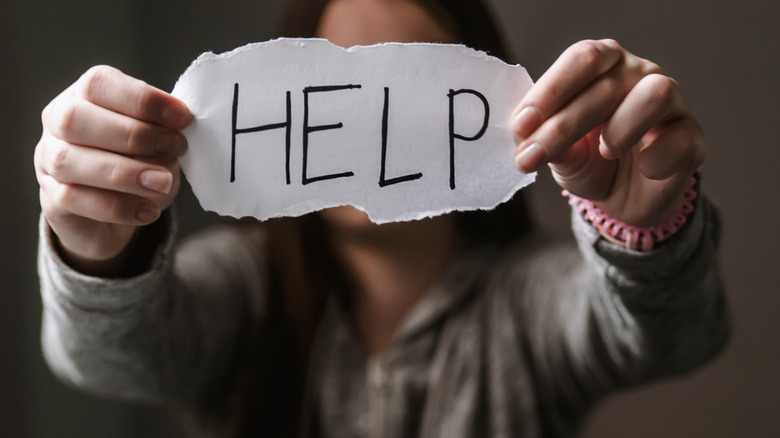 woman holding sign saying help