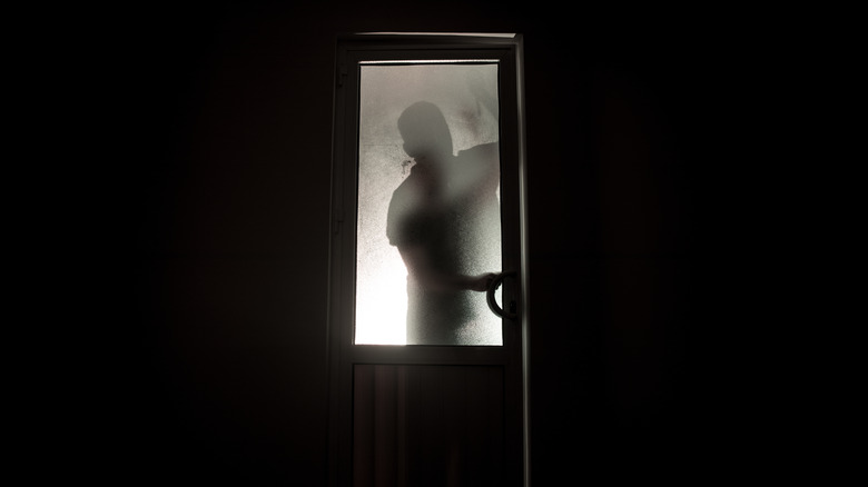 silhouette of man entering door