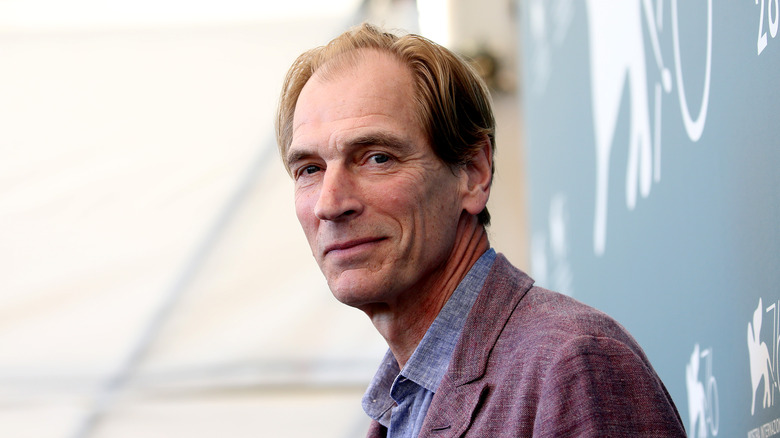 Julian Sands smiling in suit