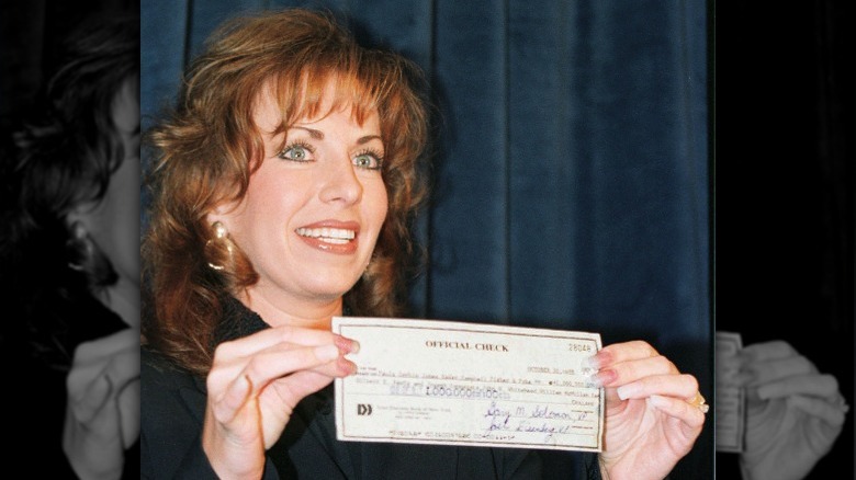 Paula Jones holding a check